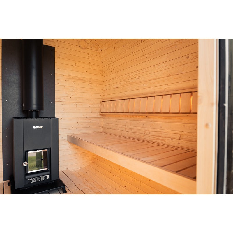Interior view of the Ula Large sauna with Harvia Sauna heater, Wood paneling and wide bench in light wood